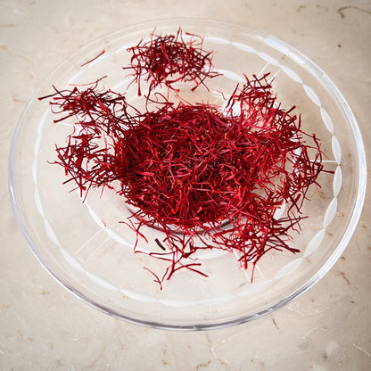 Close-up of raw saffron threads, showcasing their vibrant red color and delicate, thread-like appearance.